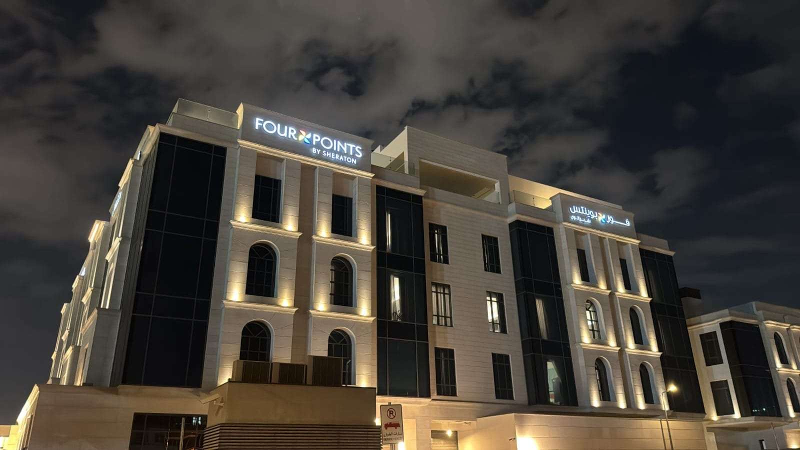 The floodlit stone facade of the Four Points by Sheraton hotel in Riyadh at night, an exterior scheme by ARAK